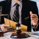 Business and lawyers discussing contract papers with brass scale on desk in office. Law, legal services, advice, justice and law concept